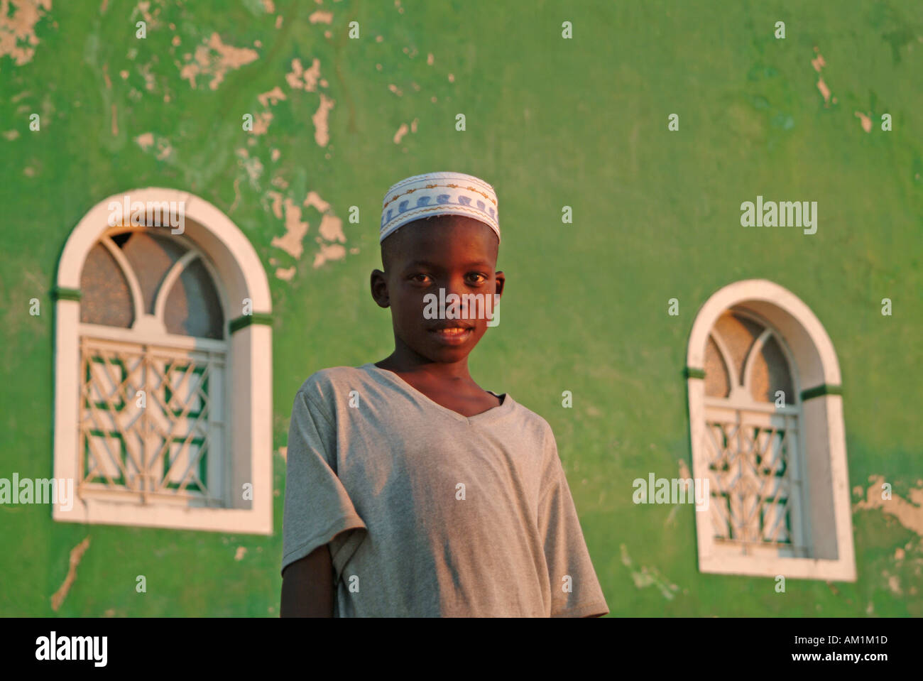 Un bambino si erge al di fuori dell'elegante color verde moschea. Ilha de Mozambico. Mozambico, Africa. Foto Stock
