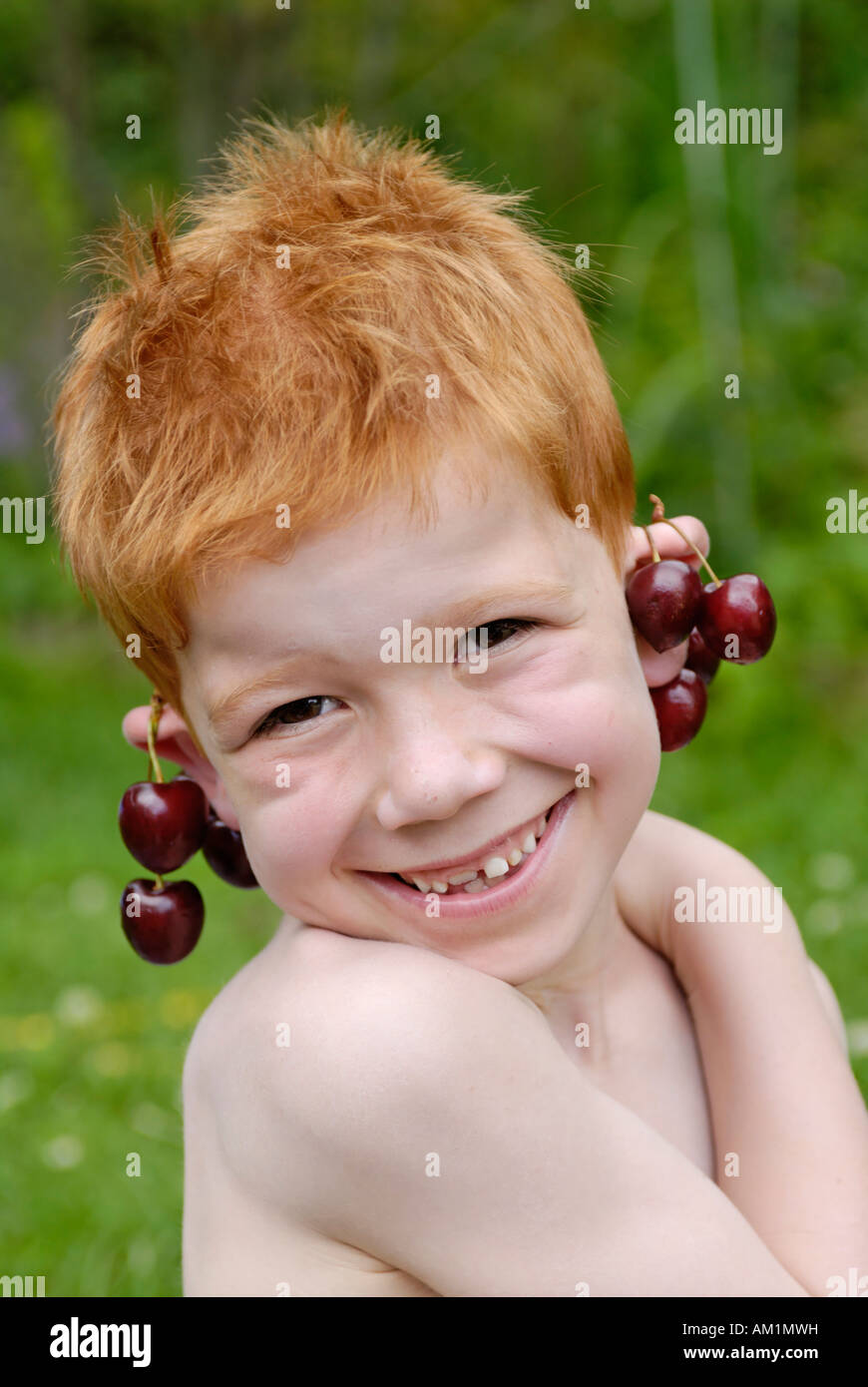 Ragazzo godendo le ciliegie Foto Stock