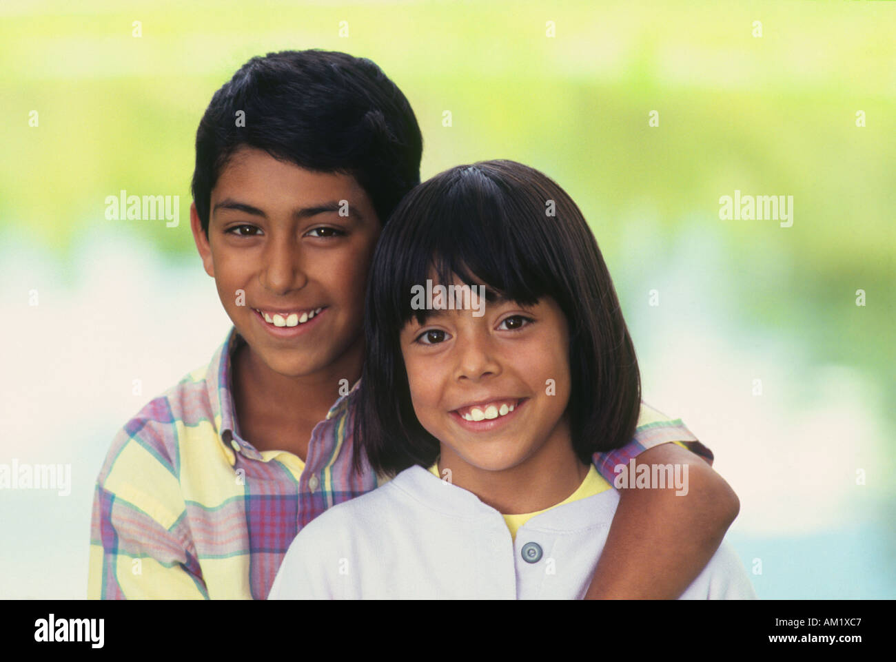 Ritratto di sorridere fratello e sorella con bracci intorno a ogni altro che pongono in posizione di parcheggio Foto Stock