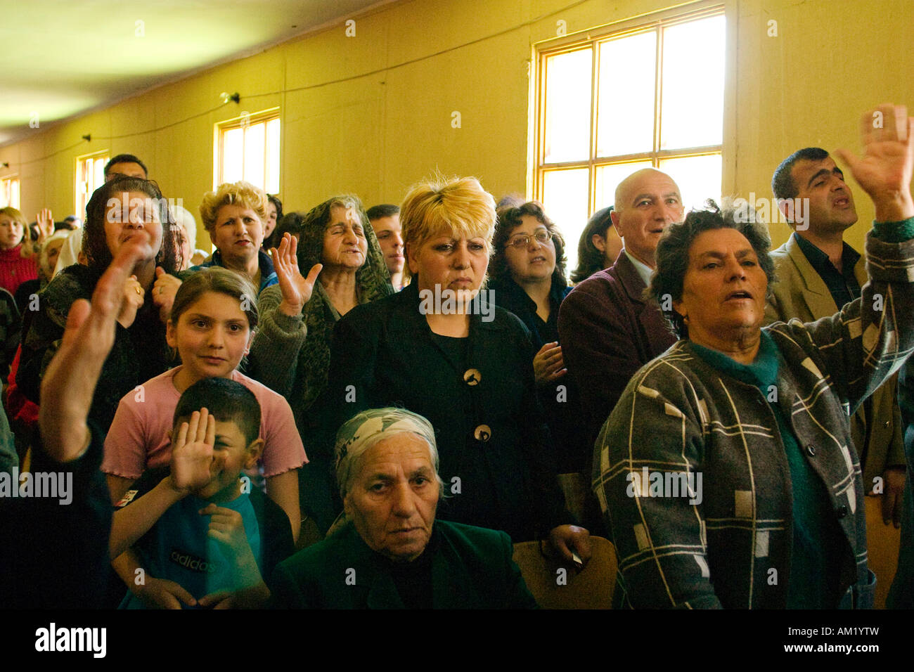 ARMENIA Vanadzor donna sollevare le mani in preghiera congregazione culto e segno durante la chiesa evangelica service Foto Stock