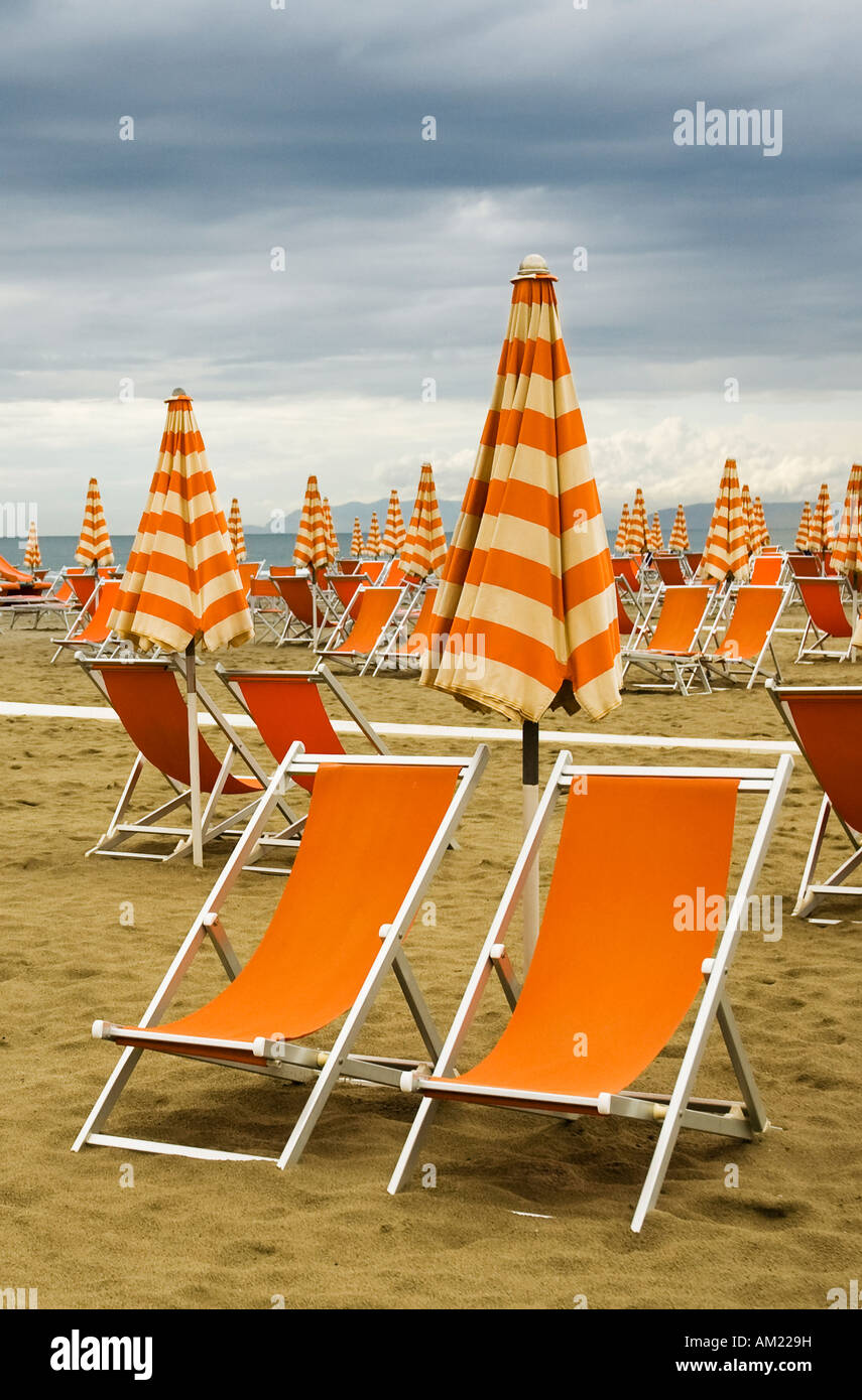 Orange sedie a sdraio su una spiaggia deserta in Viareggio Italia Foto Stock