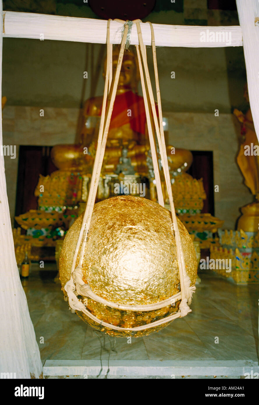 Rendendo merito mediante incollaggio foglia oro su una sfera sospesa è il metodo di supplica dai pellegrini presso alcuni Wats in Thailandia Foto Stock