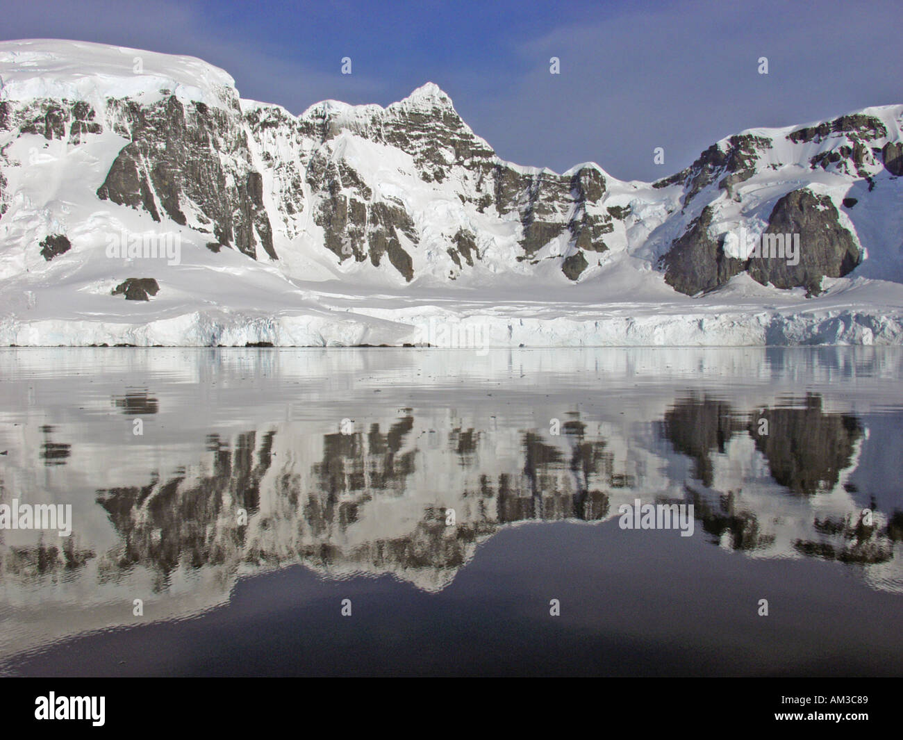 Uno specchio di riflessione di immagine di montagne coperte di neve nelle limpide acque di Paradise Harbour aka Paradise Bay Antartide Foto Stock