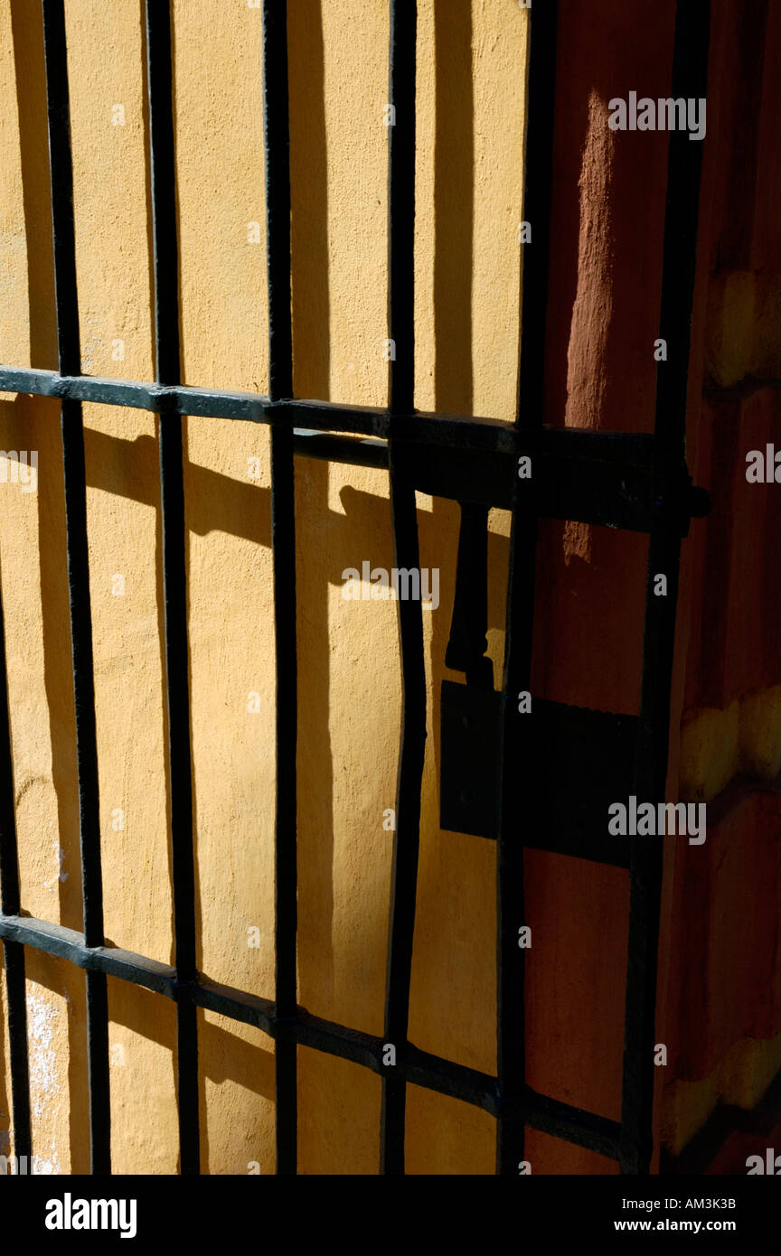 Spagna andalusia siviglia Reales Alcazares giardini in ferro battuto porta su una parete di colore giallo Foto Stock