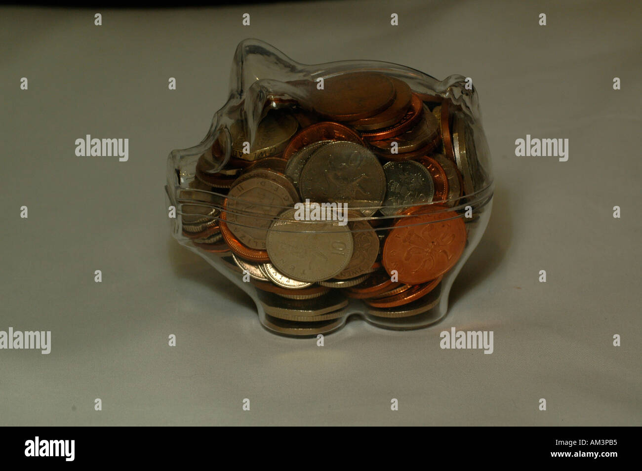salvadanaio trasparente pieno di monete in euro - Foto stock