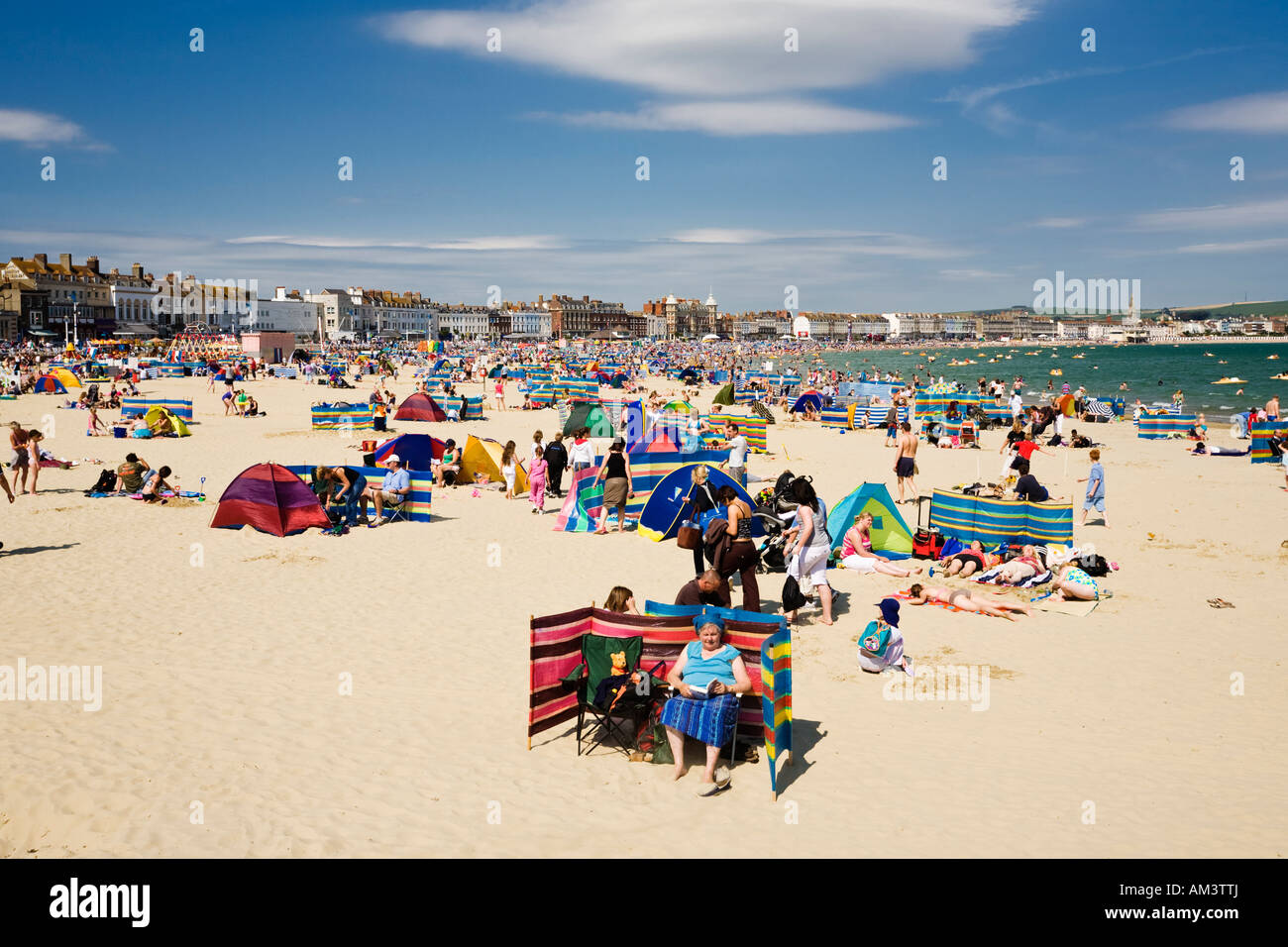 La gente sulla affollata occupato seaside beach in una calda giornata estiva, spiaggia di Weymouth Dorset, England, Regno Unito Foto Stock