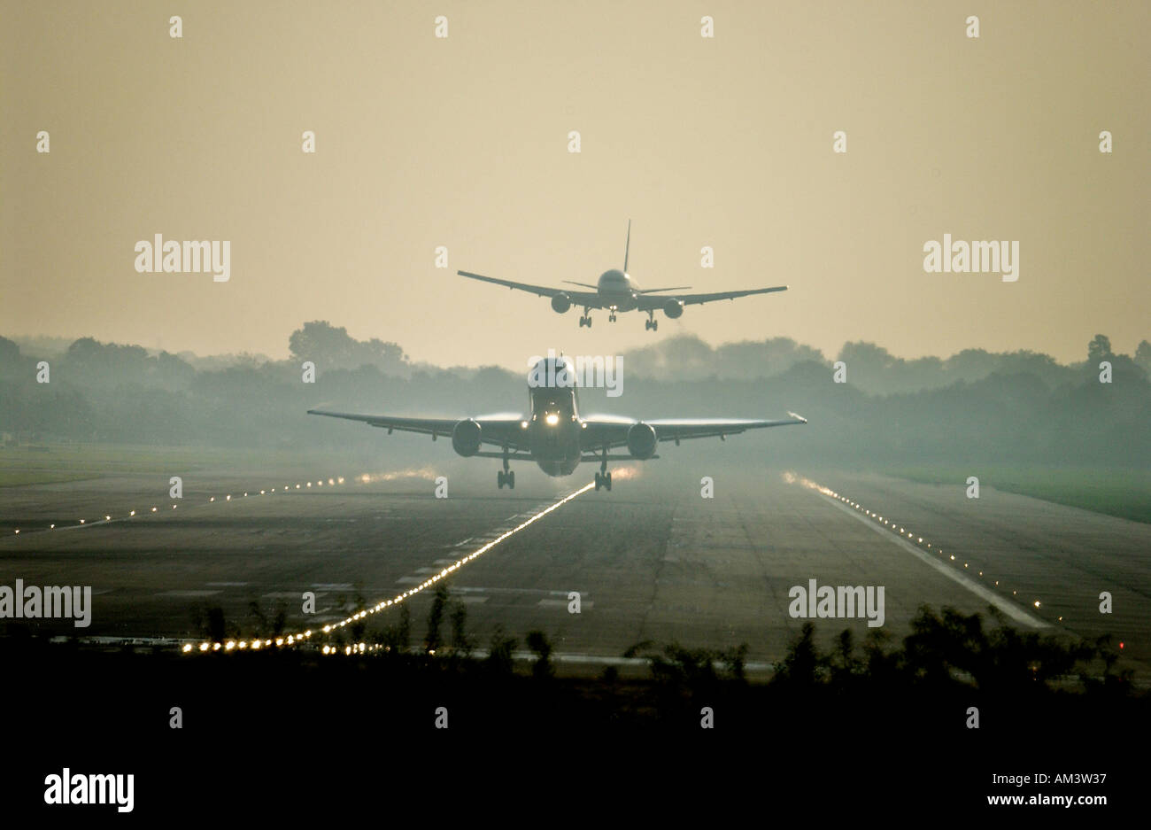 Un getto prende il largo come un altro viene a terra all'aeroporto di Londra Gatwick all'alba Foto Stock