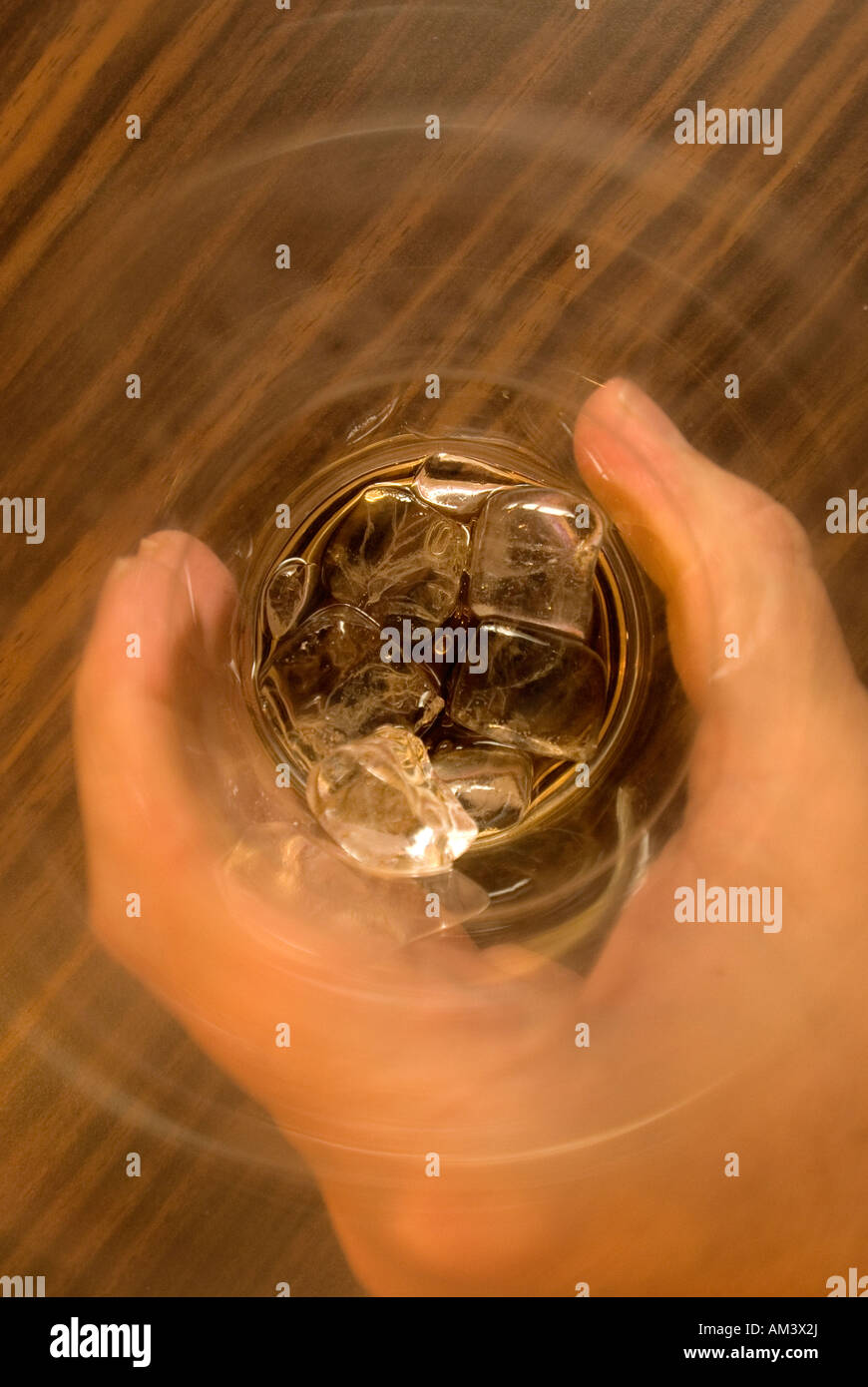 Mano che tiene un bicchiere con ghiaccio Foto Stock