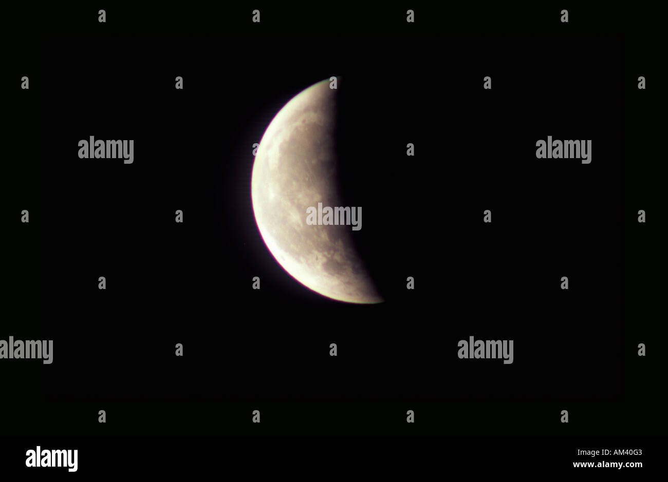 Un primo quarto di luna contro un nero starless sky Foto Stock