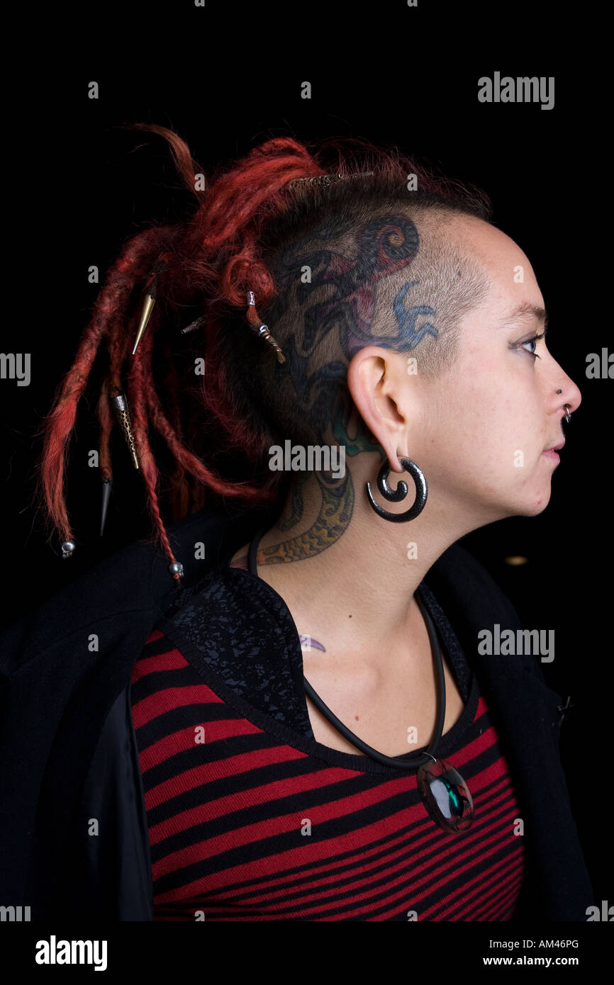 Ragazza punk con testa di tatuaggi e piercing Foto Stock