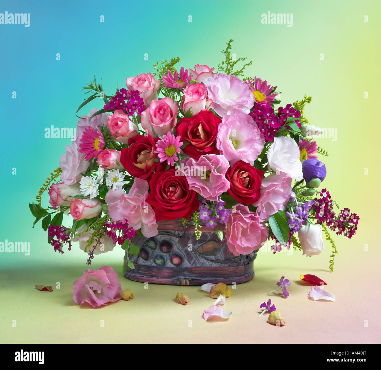 Studio disposti colorati mazzo bouquet di primavera in fiore Rose in un cesto su uno sfondo color pastello Foto Stock