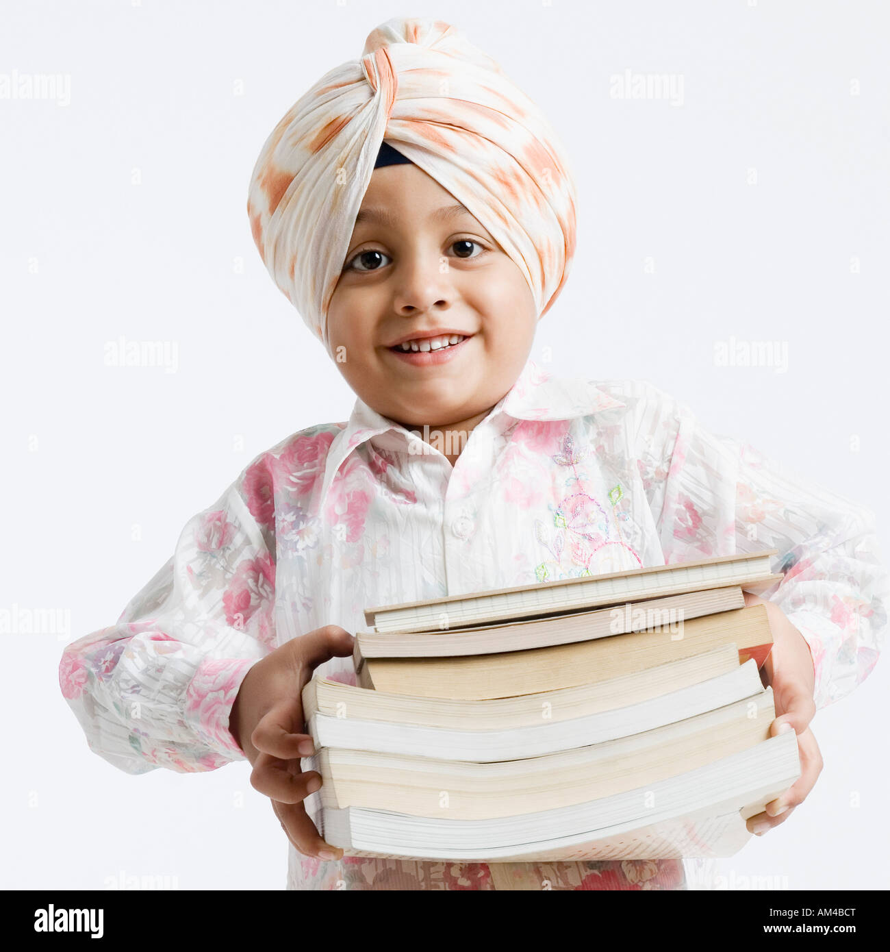 Ritratto di un ragazzo in possesso di una pila di libri e sorridente Foto Stock