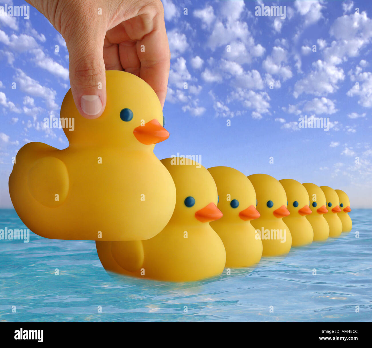 Giocattolo di gomma anatre in una fila galleggianti sull'acqua Foto Stock