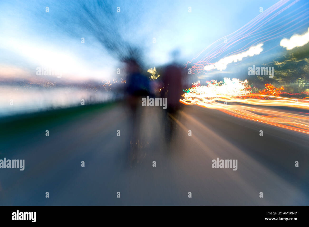 Estremamente sfocata effetto zoom immagine di persone a piedi nella distanza. Sentieri della luce e del cielo. Foto Stock