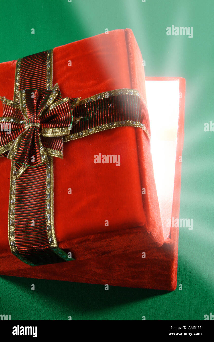Confezione regalo rossa con coperchio in posizione socchiusa e raggi di luce prorompente Foto Stock