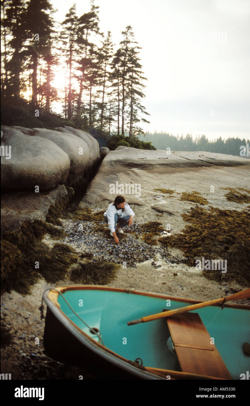 Donna su un isola rocciosa spiaggia nel Maine. Ella ha seminato a terra in un dinghy da una barca a vela Foto Stock