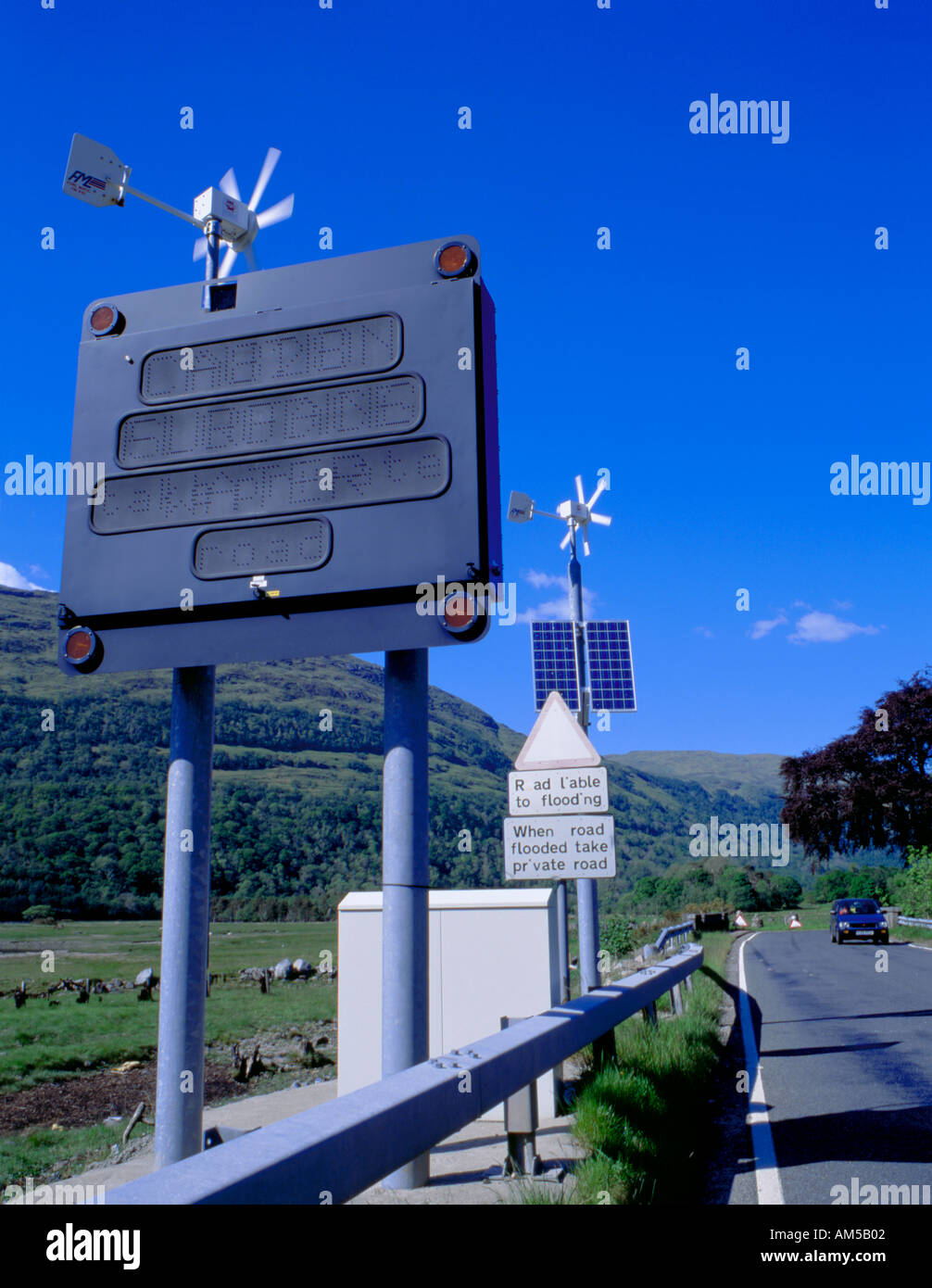 Energia solare ed eolica powered cartello stradale sulla strada accanto a Loch Creran, a nord di Oban, regione di Strathclyde, Scozia, Regno Unito. Foto Stock