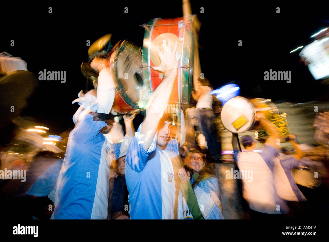 I musicisti a portare i loro tamburi luminoso ad alta oltre il tifo e ballare la folla di tifosi, celebrando un 2-1 vittoria in Coppa del mondo. Foto Stock