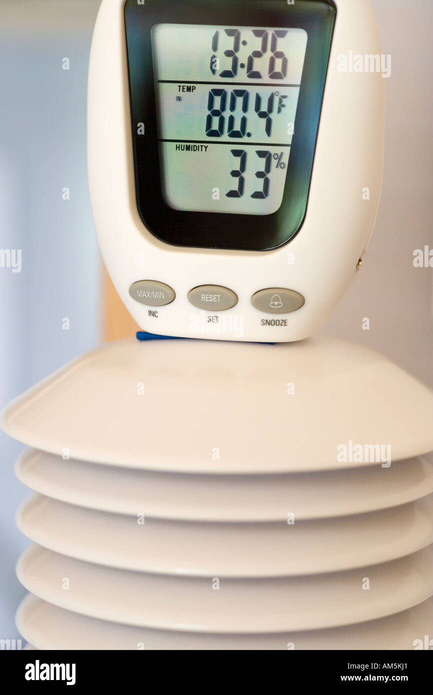 Termometro e igrometro unità accoppiato con il termostato di una casa sperimentale che viene riscaldata e alimentato da energia solare Foto Stock