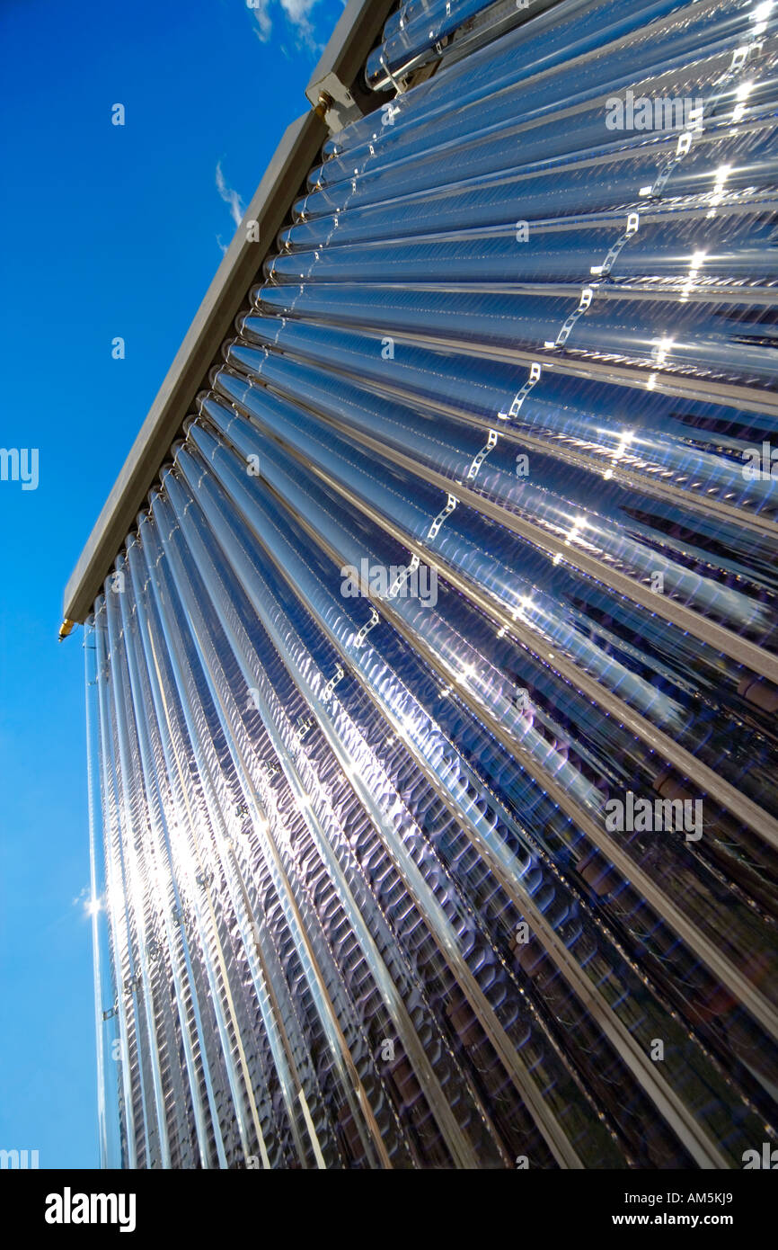 Solare di acqua calda pannelli contro un cielo blu con forti riflessi di luce del sole. Foto Stock