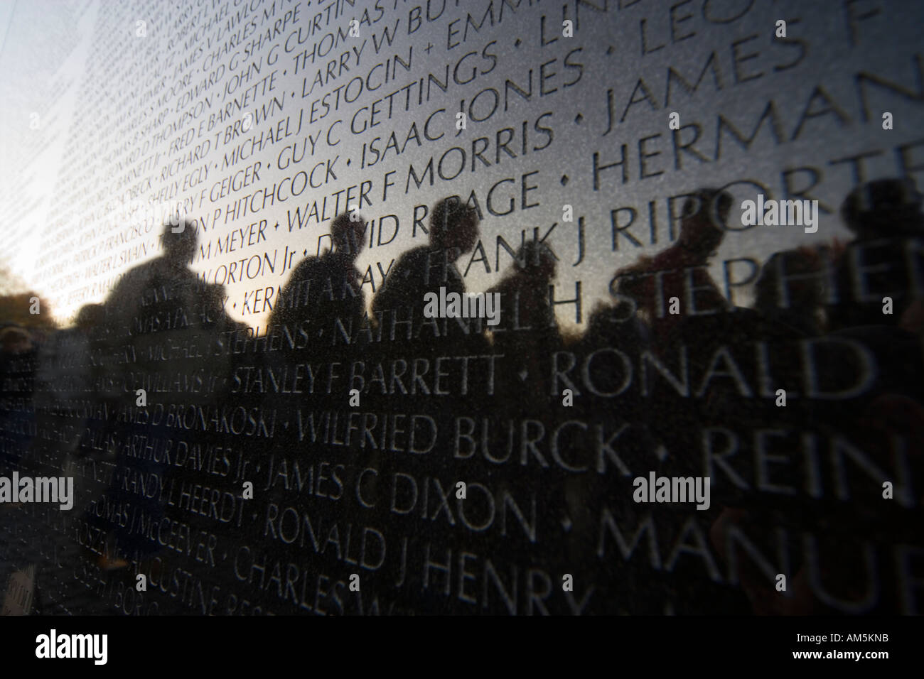 I veterani del Vietnam War Memorial a Washington DC. Sagome di visitatori riflettente e la fusione con i nomi dei caduti. Foto Stock