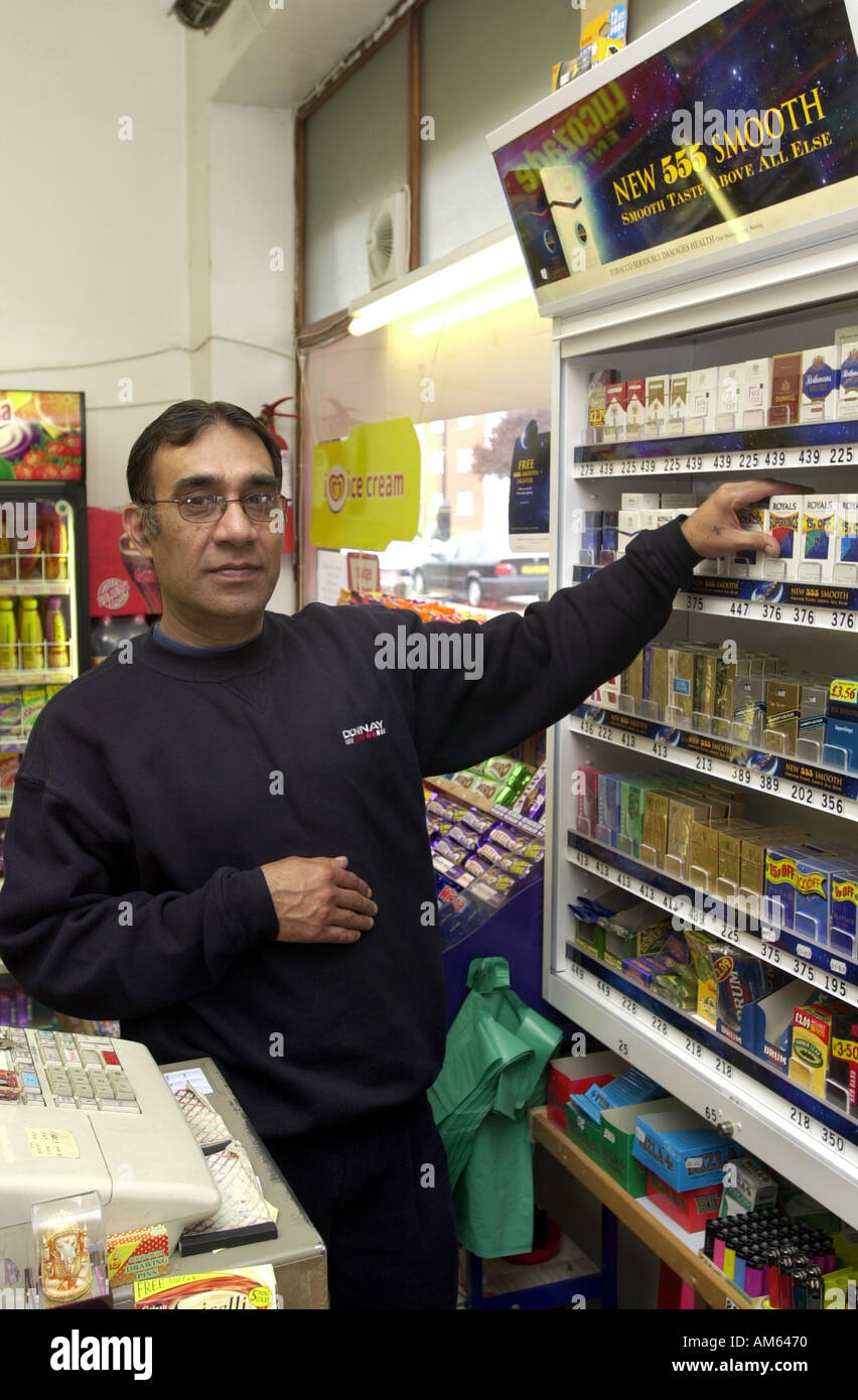 Uomo che serve a un angolo shop UK Foto Stock