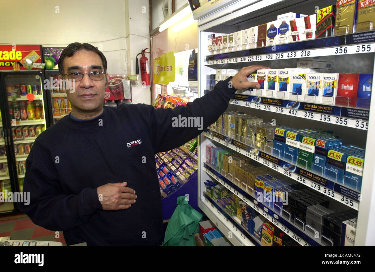 Uomo che serve a un angolo shop UK Foto Stock