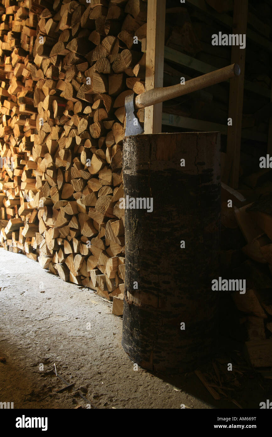 Cantina di legno con legna da ardere stock, blocco di trinciatura e ax Foto Stock