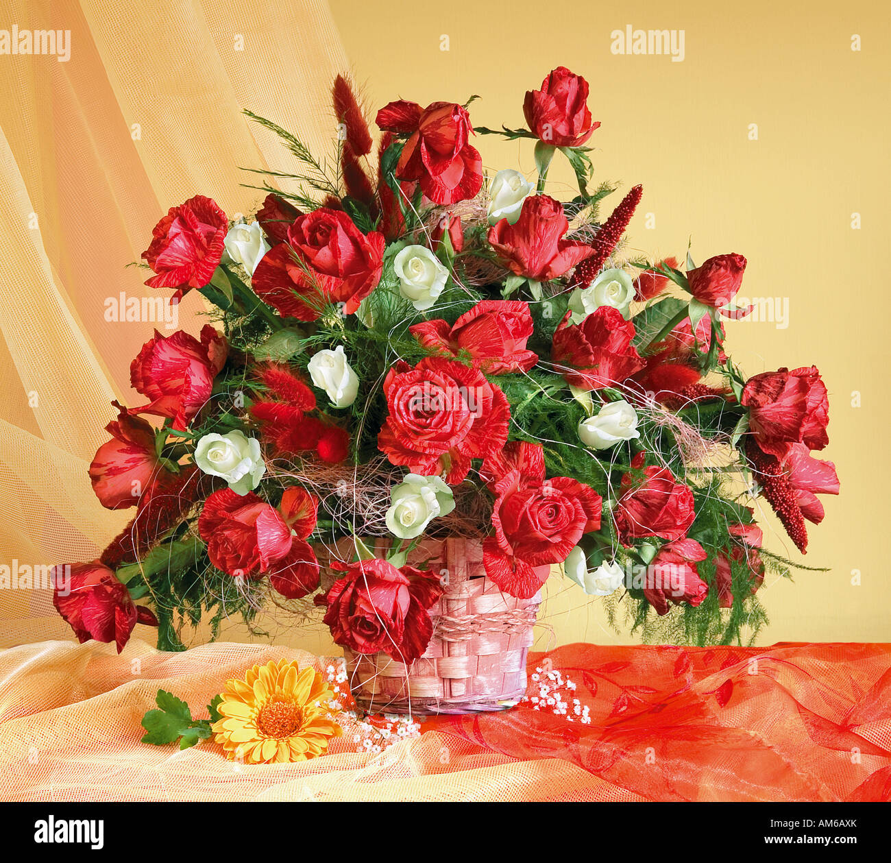 Studio disposti mazzetto bouquet di rose rosse in cesto su un pastello sfondo giallo Foto Stock