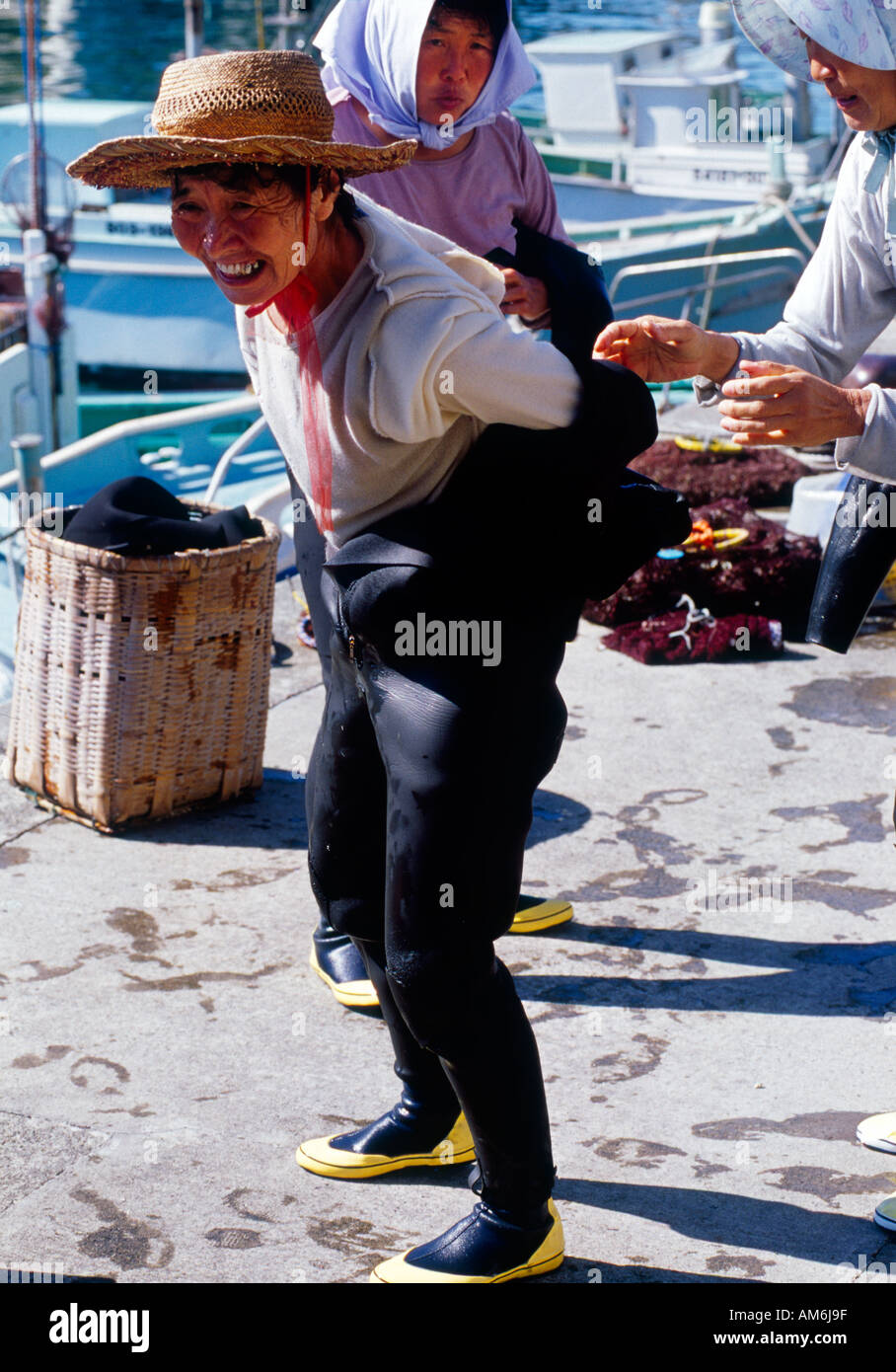 Amasan giapponese Pearl Diver eliminando i suoi drysuit dopo giorni di immersioni subacquee Foto Stock