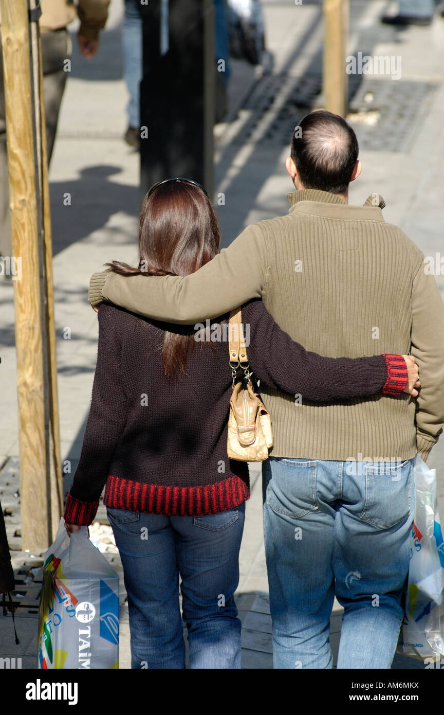 Trenta qualcosa di giovane camminando a braccetto, da dietro Foto Stock