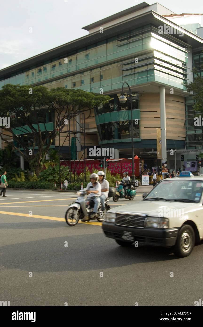 Automobili e motociclette attraversando un incrocio in Singapore Foto Stock