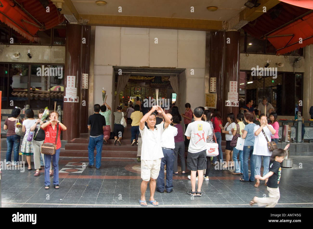 Buddisti facendo offerte a un tempio in Singapore Foto Stock