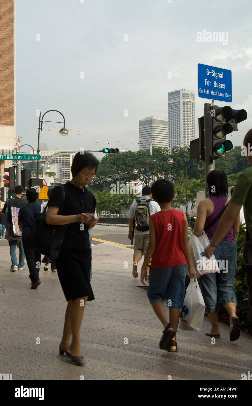 Persone su una strada trafficata in Singapore Foto Stock