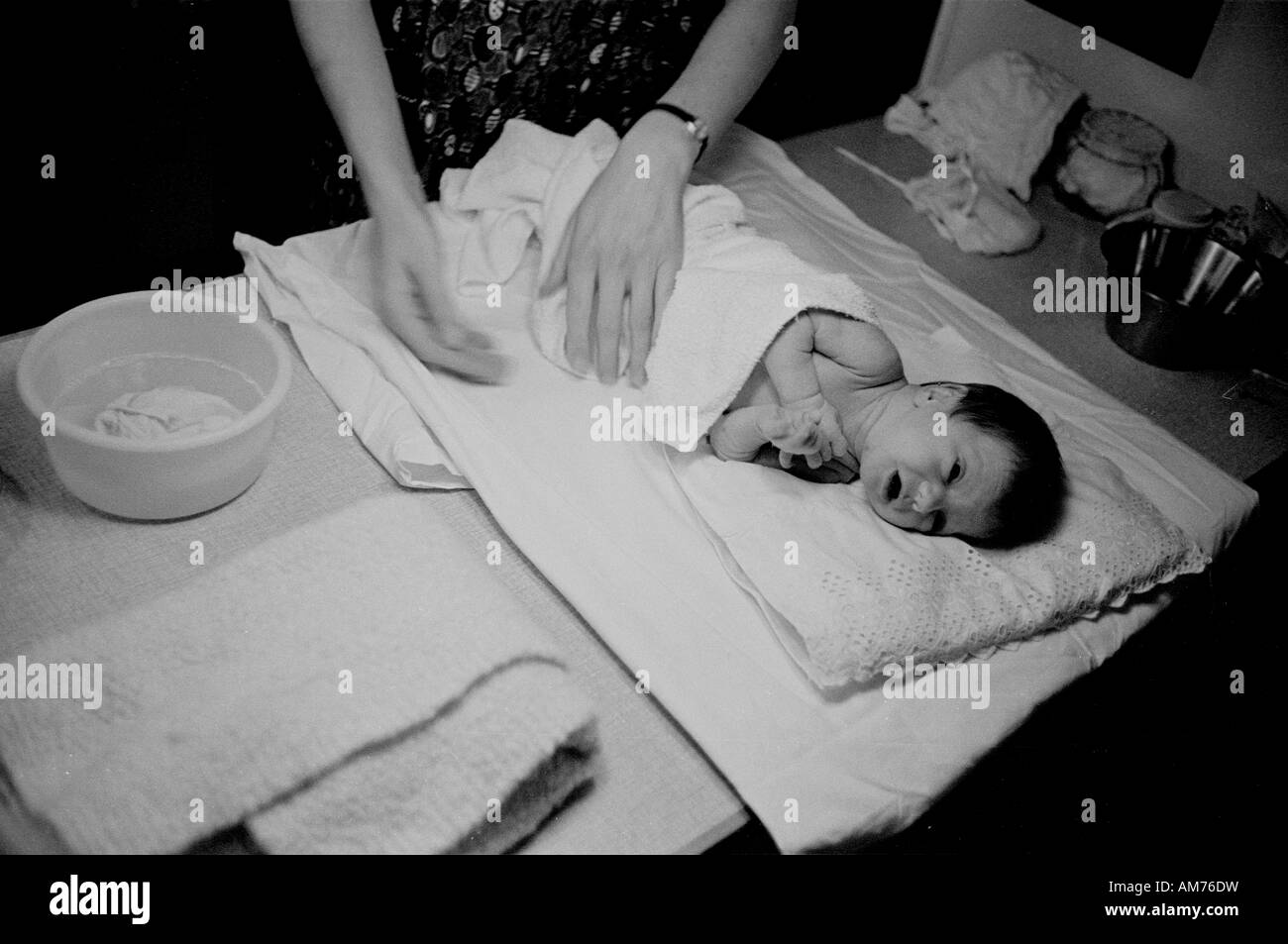 Tendendo un neonato negli anni sessanta Foto Stock