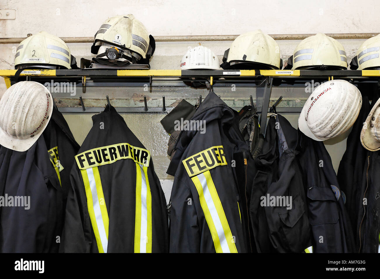 Cappotti e caschi di pompieri nel quartiere maschile, Germania Foto Stock