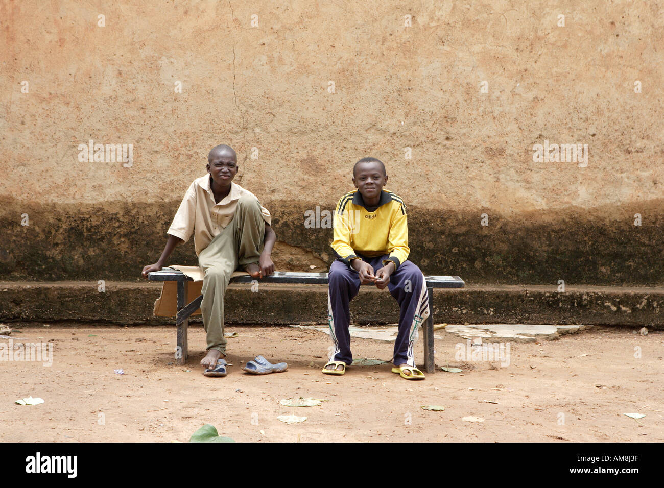 Due ragazzi di Burkina Fasso seduta su una panchina al di fuori della loro casa in un sobborgo di Ouagadougou Foto Stock