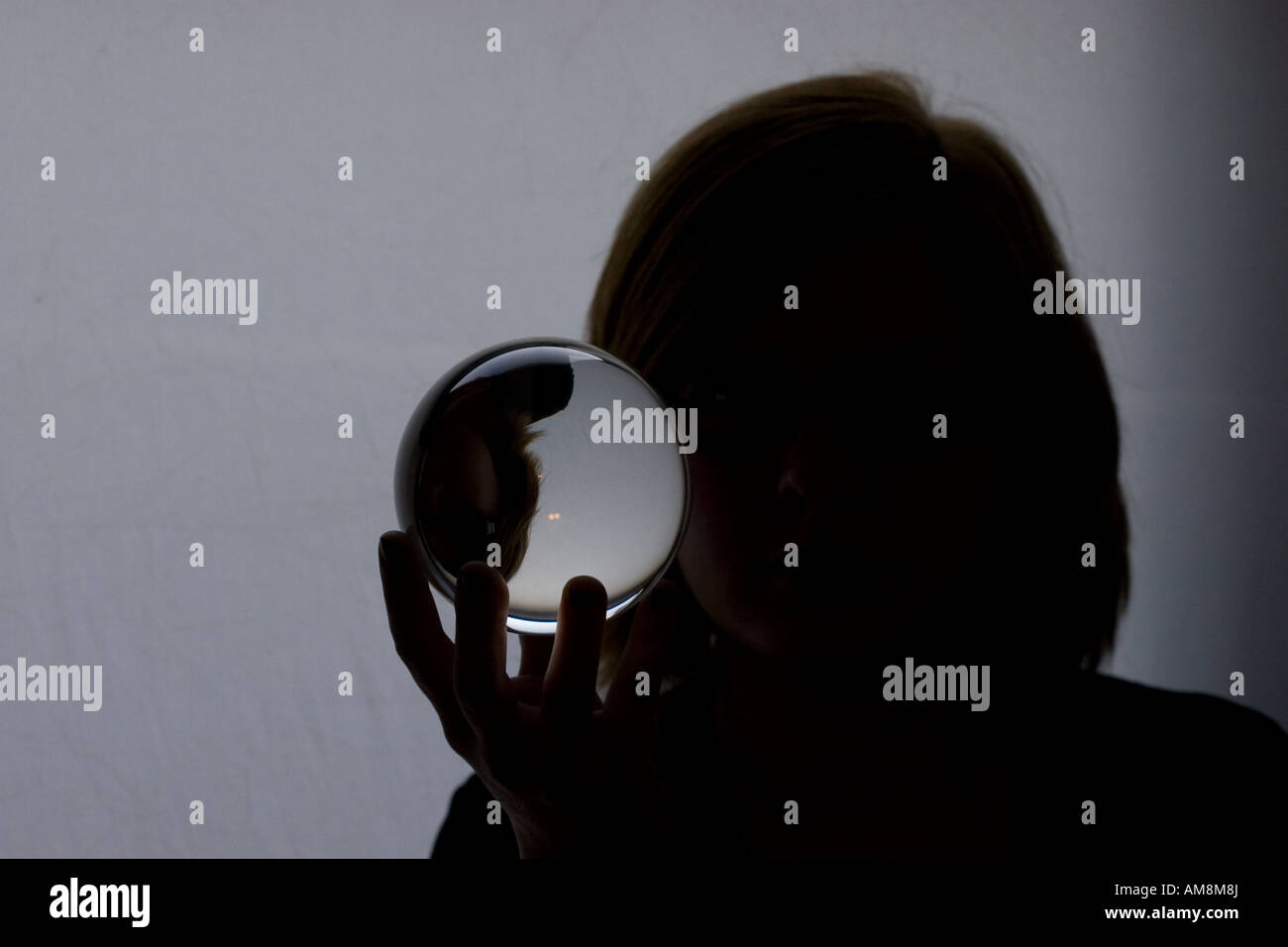Twoman tenendo in una sfera di vetro con la sua immagine rifratti all'interno mentre standi Foto Stock