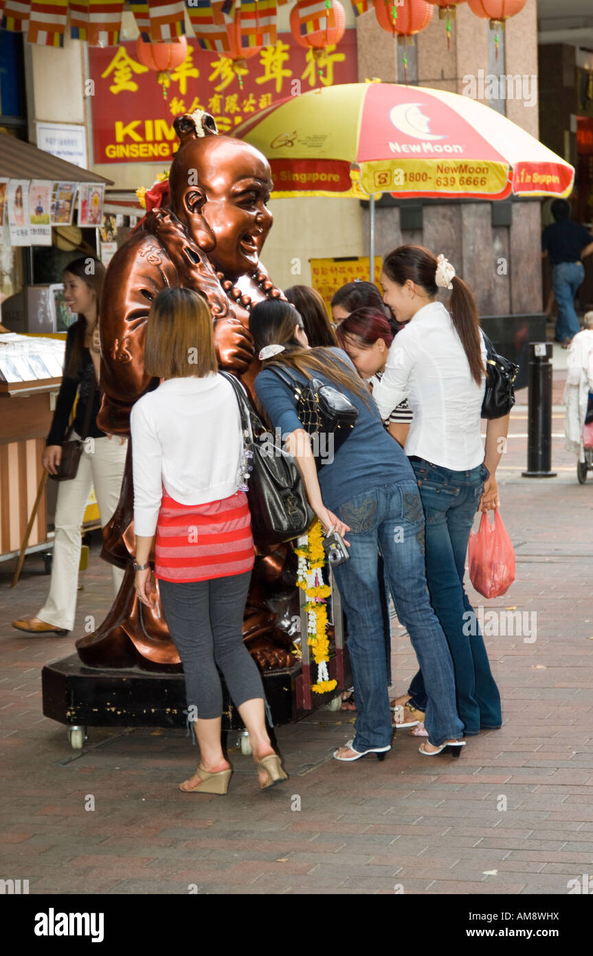 Ragazze cinesi avente foto scattata con la statua del Buddha per buona fortuna in Sinapore Foto Stock