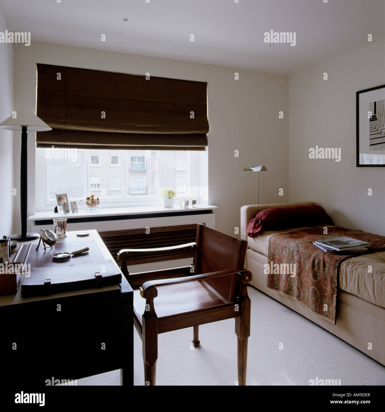 Camera da letto con letto singolo, scrivania e poltrona in pelle in un lussuoso appartamento di Londra Foto Stock