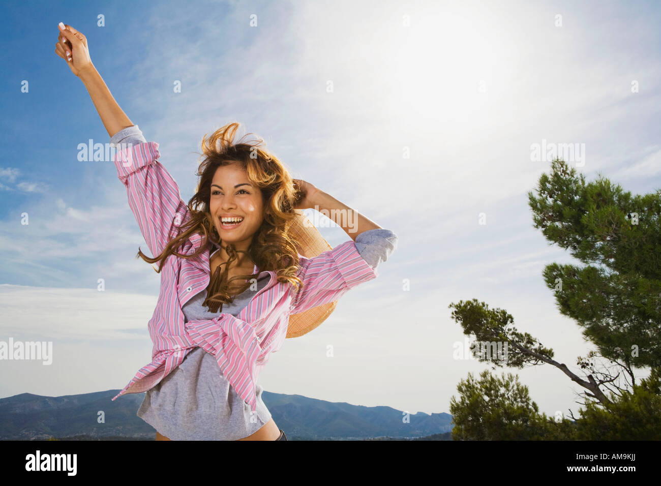 Donna sorridente all'aperto con braccio nell'aria. Foto Stock