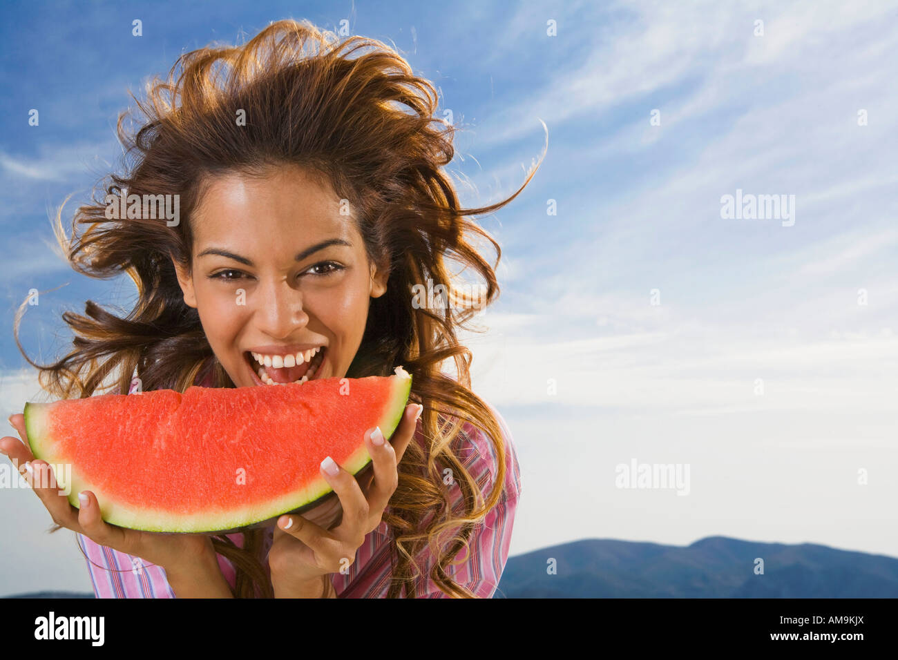 Donna che ride e mangiando anguria all'esterno. Foto Stock