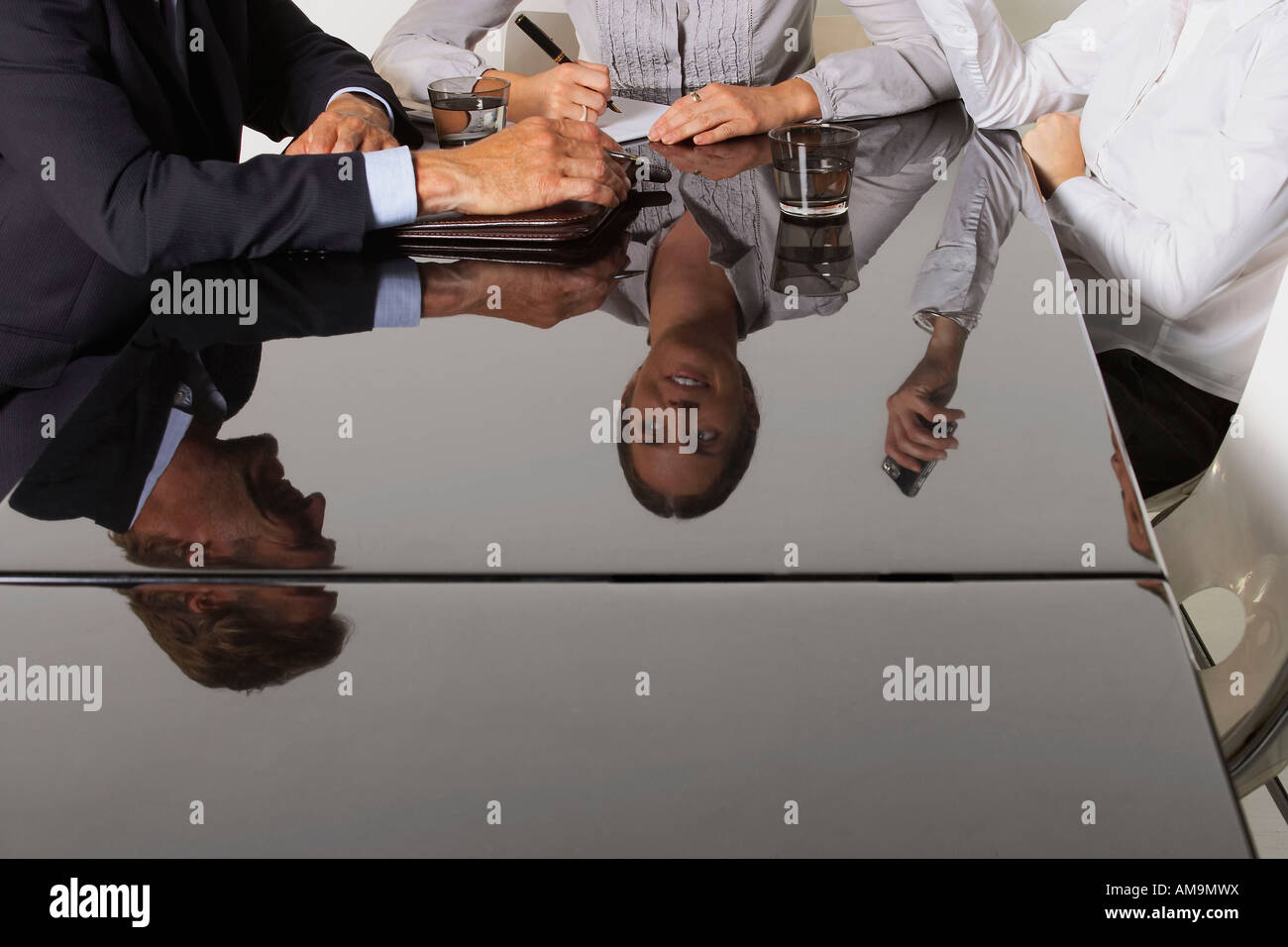 Tre uomini di affari che la riflessione in una tabella. Foto Stock