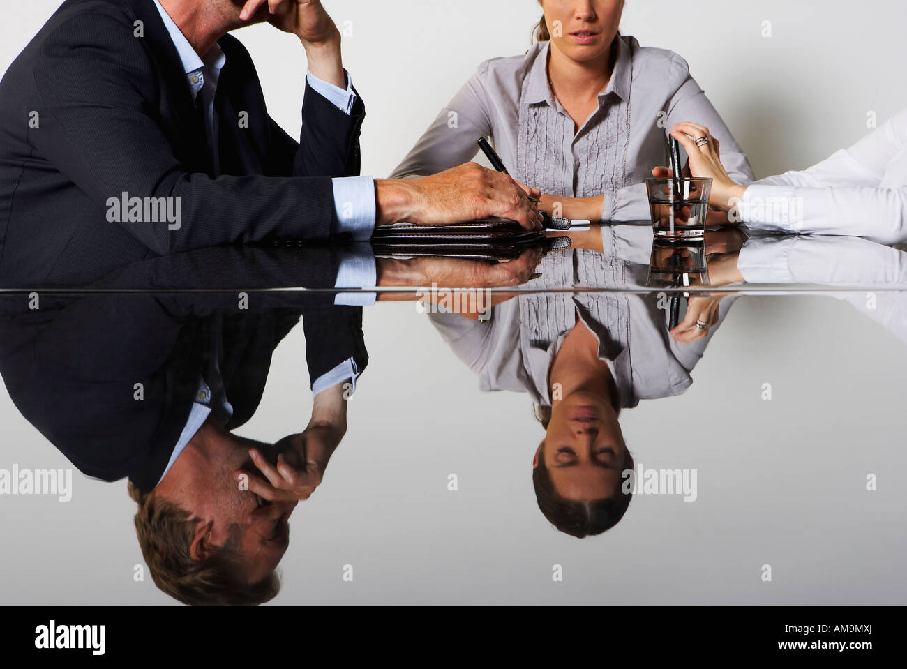 Tre uomini di affari che la riflessione in una tabella. Foto Stock