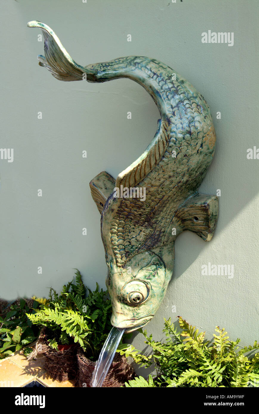 Ceramiche fatte a mano studio fontana acqua montato a parete carp pesce placca motif gettato ombra Foto Stock