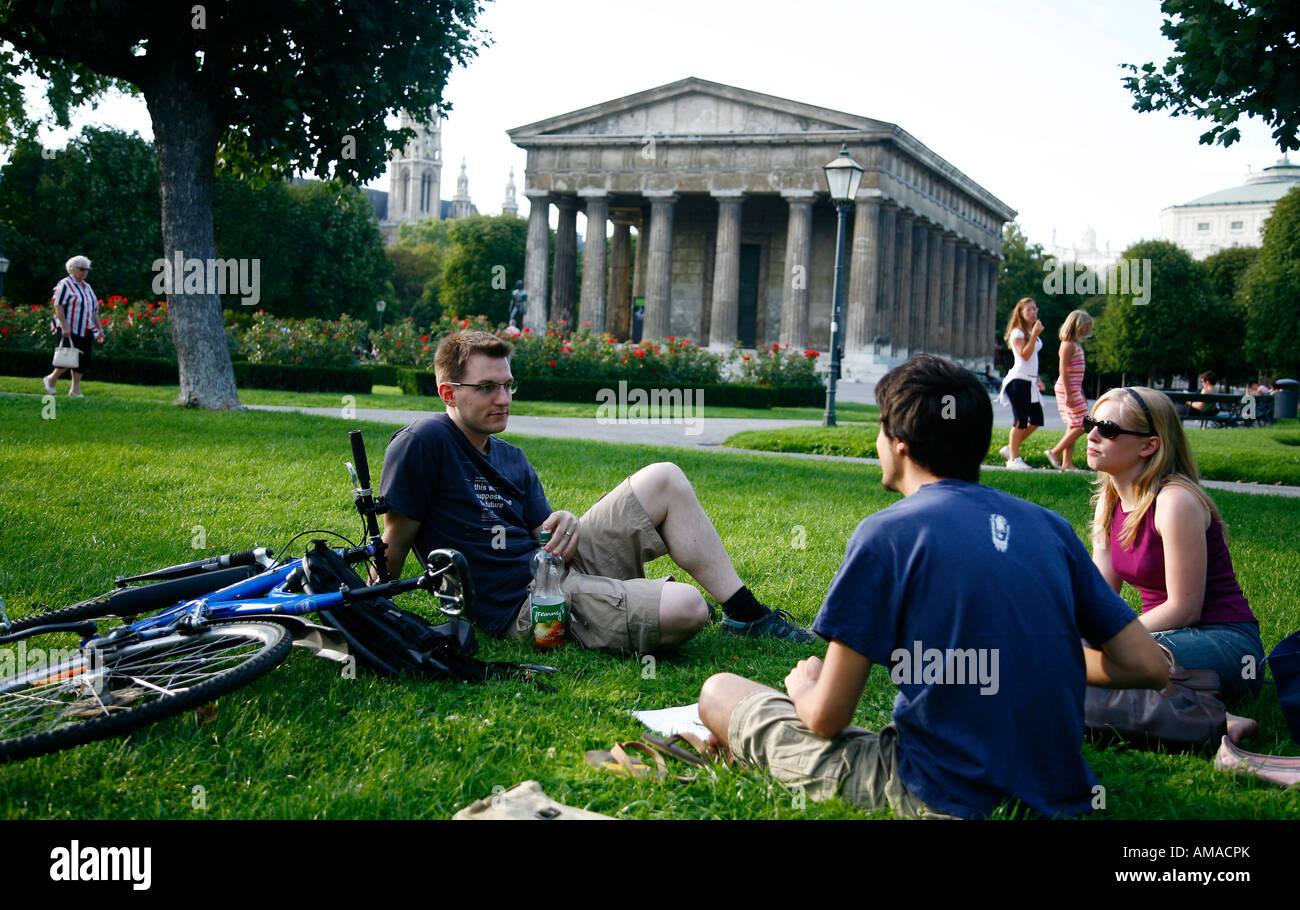 Agosto 2008 - la gente seduta al parco Volksgarten con il Tempio di Teseo in background Vienna Austria Foto Stock