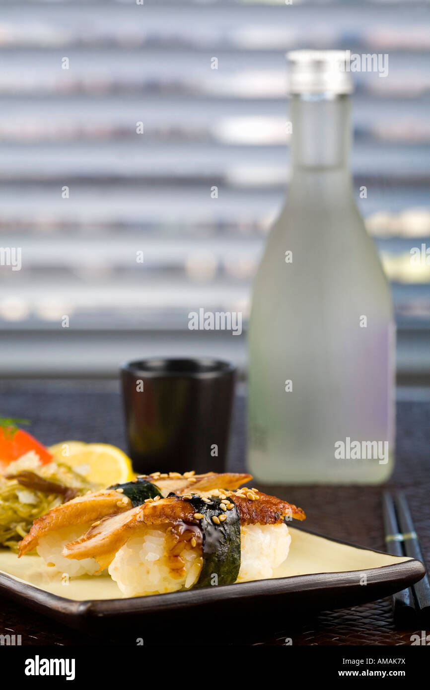 Il nigiri sushi davanti ad una bottiglia di sake Foto Stock