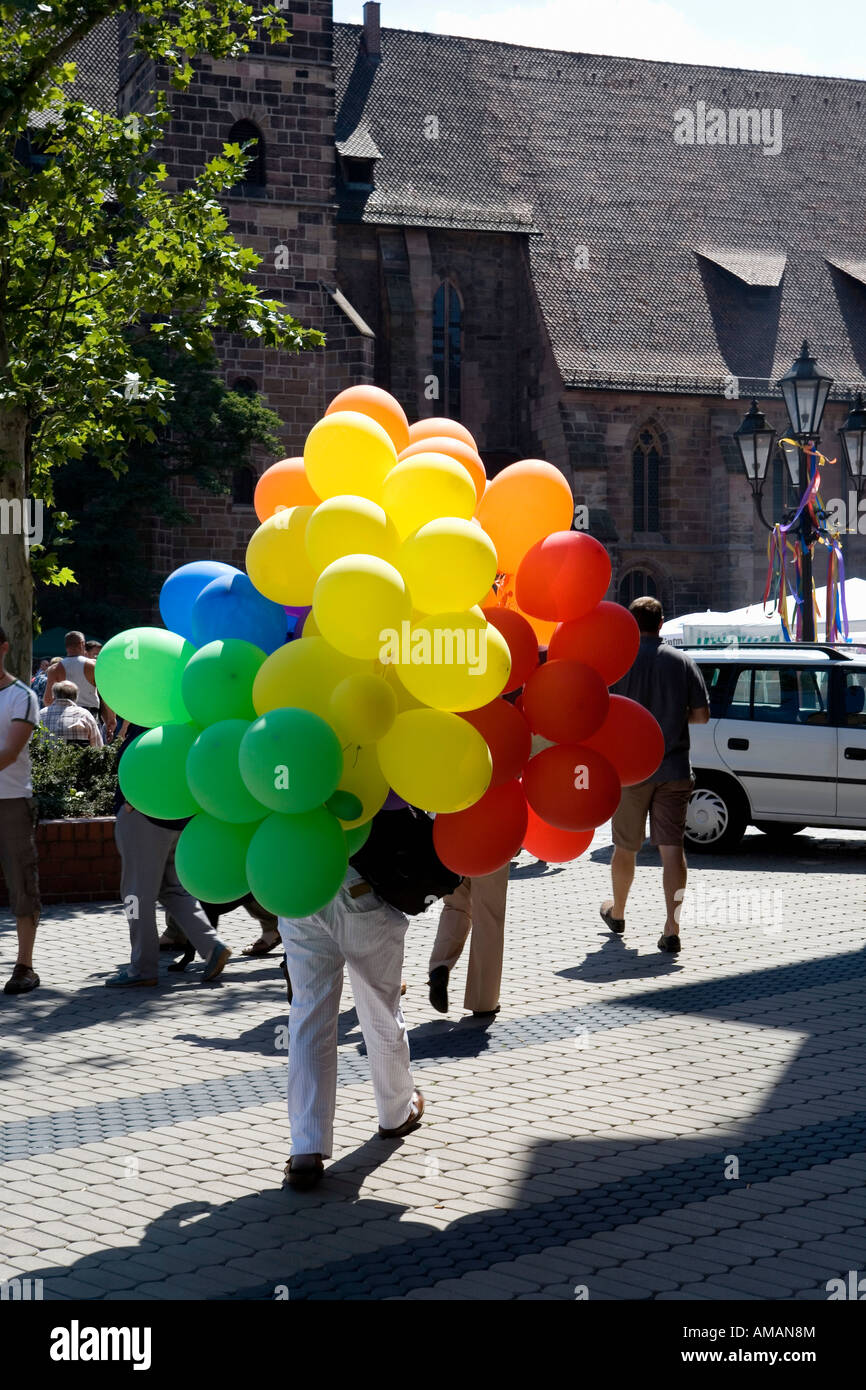 Una persona che porta un grappolo di palloncini Foto Stock