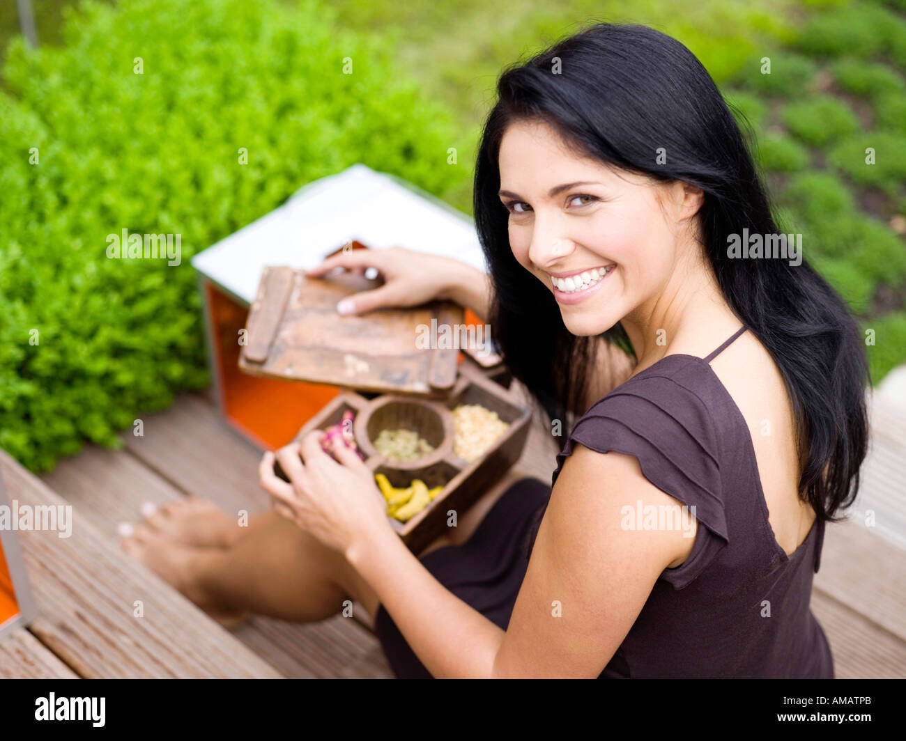 Donna che mantiene la casella di spezie, sorridente, vista in elevazione Foto Stock