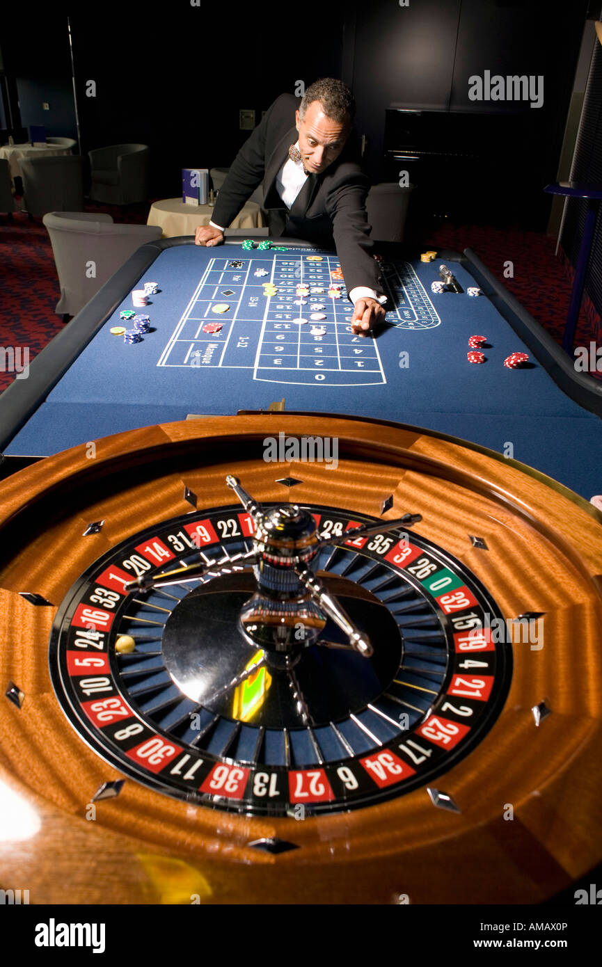 Euro Casino. L'uomo immissione puntata sul tavolo della roulette Foto Stock